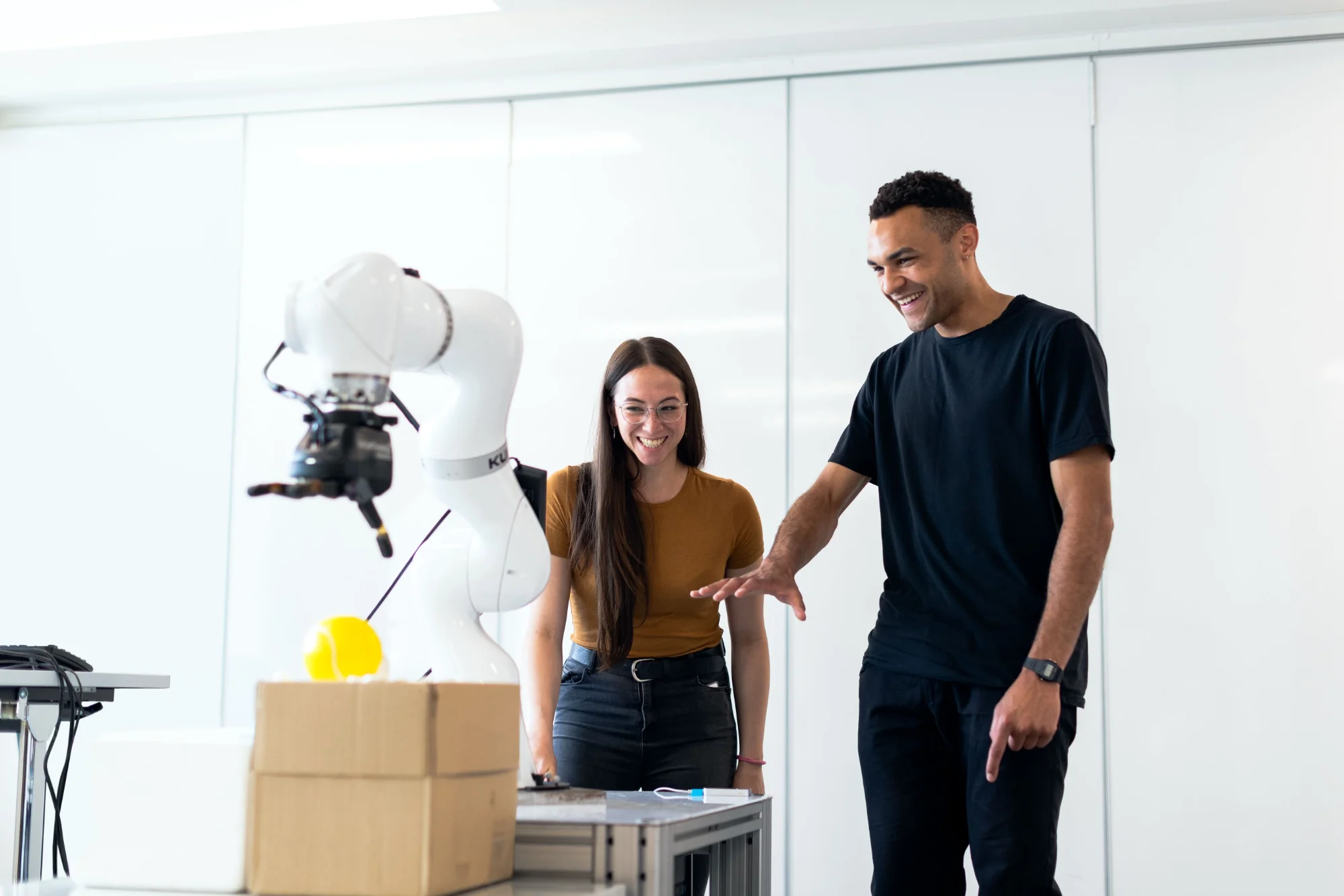 Engineers testing and interacting with a robotic arm in an enterprise AI lab
