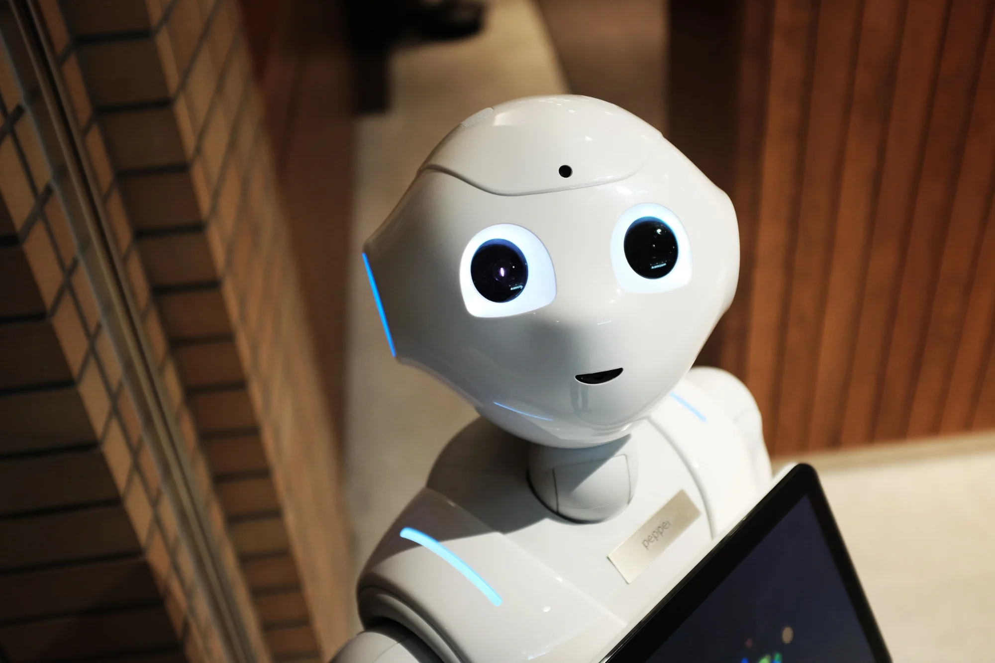 Robotic hand reaching toward a human hand, representing AI human collaboration