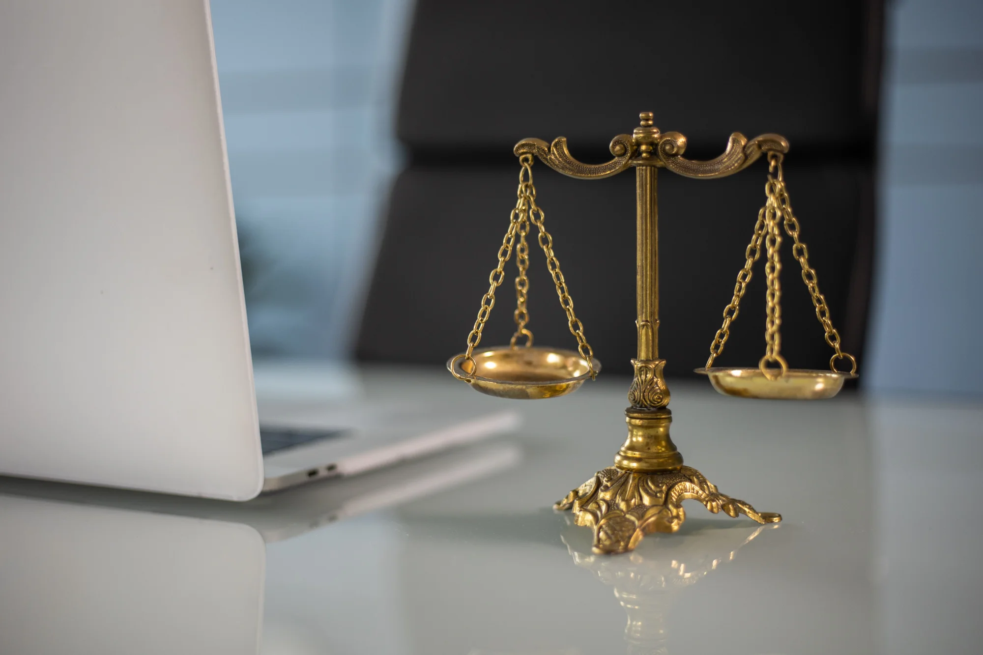 Gold balance scale next to laptop representing AI governance risk and value evaluation
