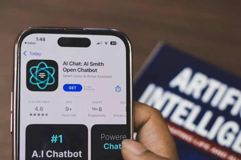 AI chatbot app on phone next to artificial intelligence book