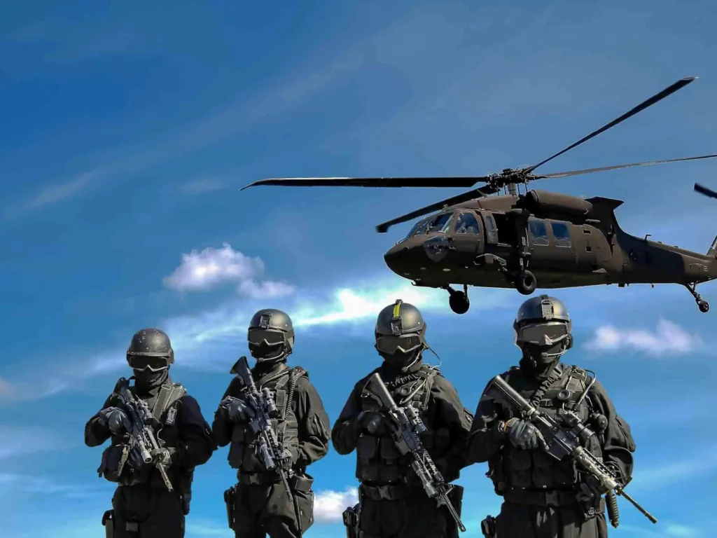 Soldiers in combat gear with helicopter