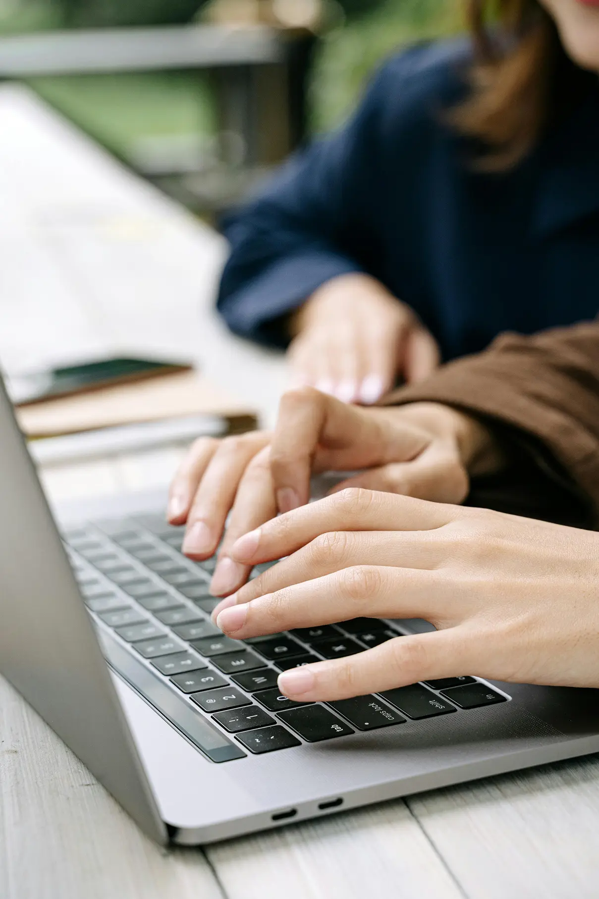 hands typing on a laptop keyboard