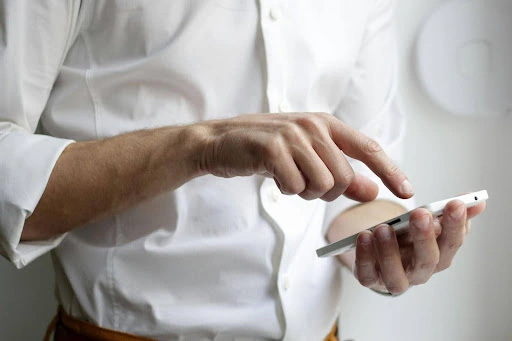 Person using a smartphone in a white shirt
