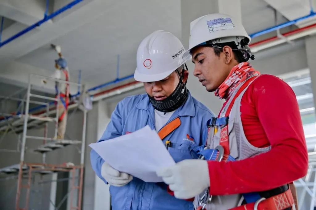 Two construction workers reviewing a document