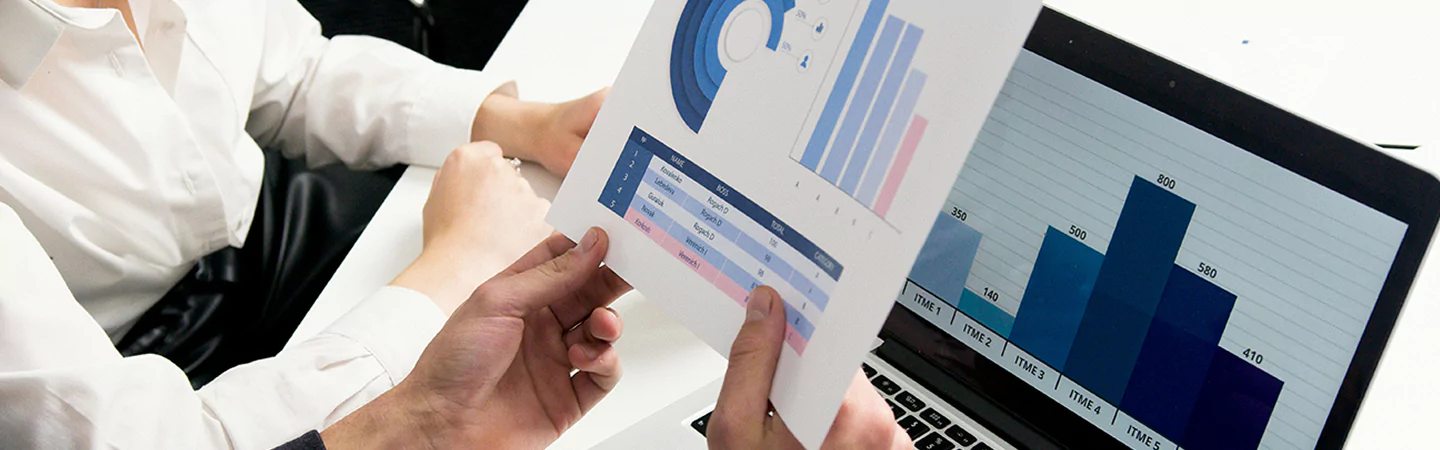 Team reviewing printed and digital charts in meeting setting