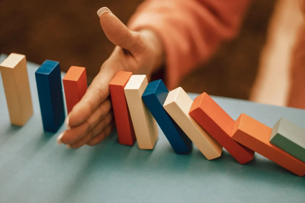 Hand halting a domino effect representing shadow AI enterprise risk governance
