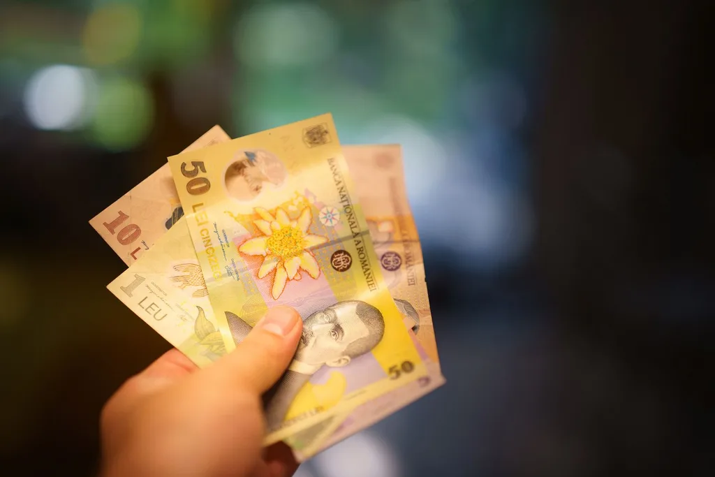 Hand holding money representing direct AI investment and ROI. 

