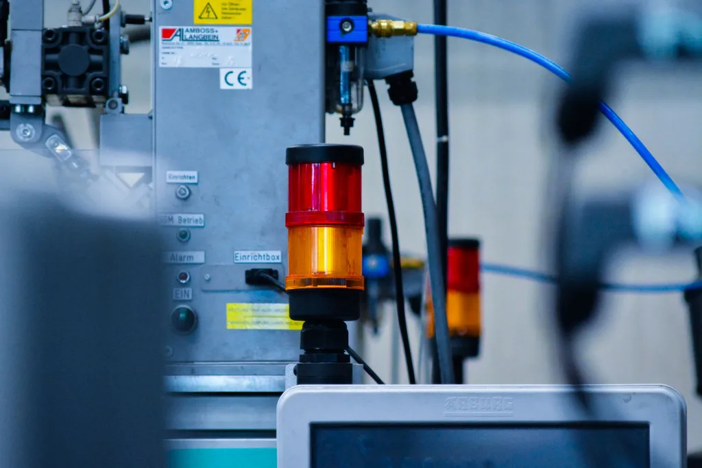 Automated industrial machine running with status warning light.