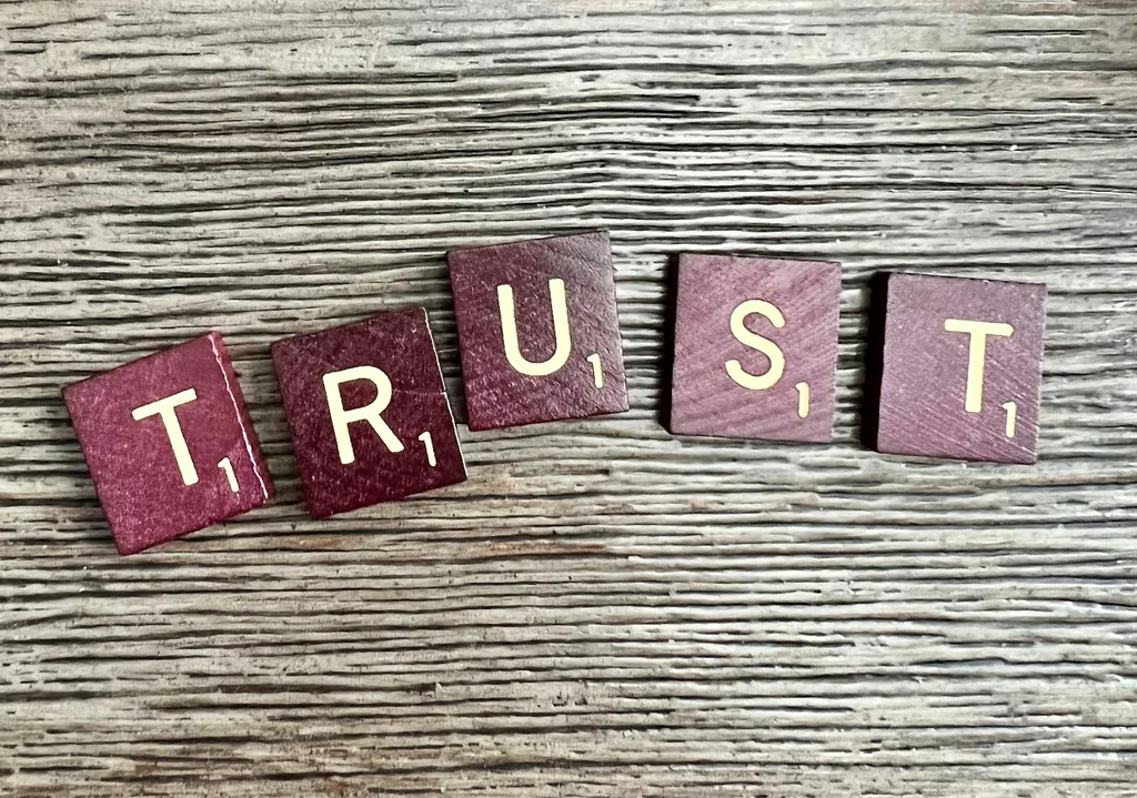 Wooden letter blocks spelling TRUST on a rustic surface